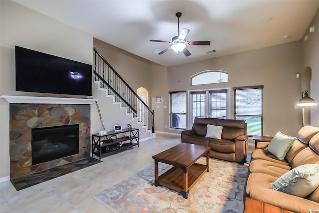 4507 Cinco Forest Trl, Katy, TX 77494 - living room featuring a fireplace, stairway, a ceiling fan, and arched walkways