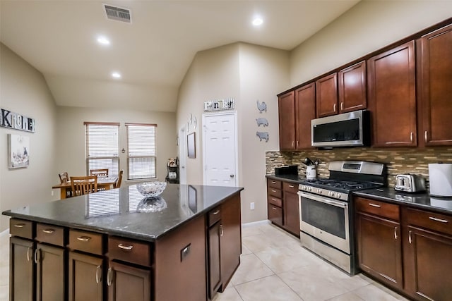 4507 Cinco Forest Trl, Katy, TX 77494 - kitchen featuring stainless steel appliances, lofted ceiling, decorative backsplash, a kitchen island, and light tile patterned floors