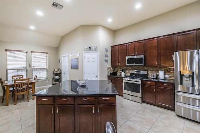 4507 Cinco Forest Trl, Katy, TX 77494 - kitchen with stainless steel appliances, light tile patterned floors, decorative backsplash, dark stone counters, and vaulted ceiling