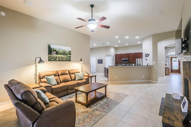 4507 Cinco Forest Trl, Katy, TX 77494 - living room with arched walkways, ceiling fan, light tile patterned flooring, a tile fireplace, and recessed lighting