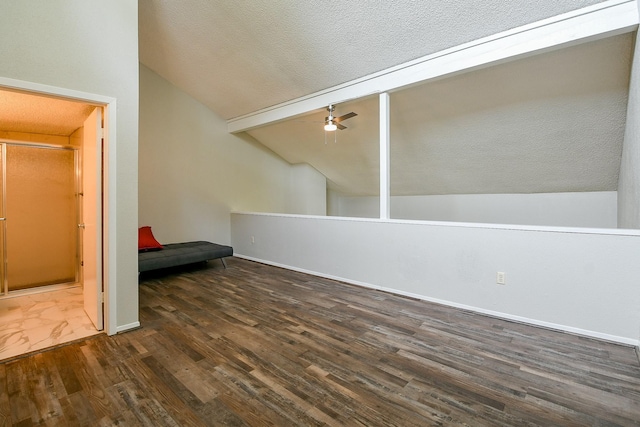 325 Carolcrest Ln Unit 3, Livingston, TX 77351 - additional living space featuring vaulted ceiling, dark wood-style floors, a ceiling fan, and a textured ceiling