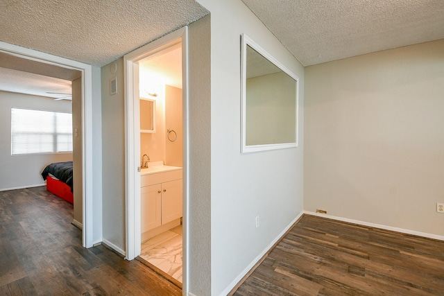 325 Carolcrest Ln Unit 3, Livingston, TX 77351 - corridor featuring a textured ceiling and dark wood-style flooring