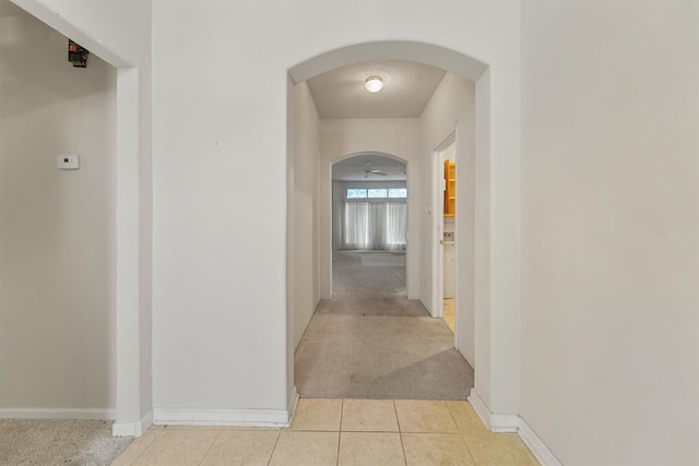 5723 Painted Trail Dr, Houston, TX 77084 - hallway featuring arched walkways, light colored carpet, and light tile patterned floors