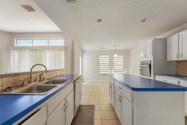5723 Painted Trail Dr, Houston, TX 77084 - kitchen featuring appliances with stainless steel finishes, backsplash, white cabinets, dark countertops, and a center island