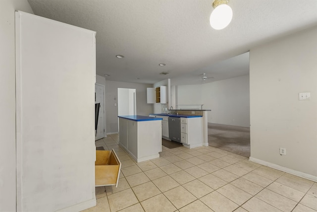 5723 Painted Trail Dr, Houston, TX 77084 - kitchen with dishwasher, dark countertops, light tile patterned floors, a ceiling fan, and a peninsula