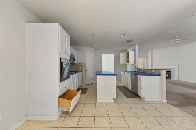 5723 Painted Trail Dr, Houston, TX 77084 - kitchen featuring appliances with stainless steel finishes, a ceiling fan, dark countertops, white cabinets, and decorative backsplash