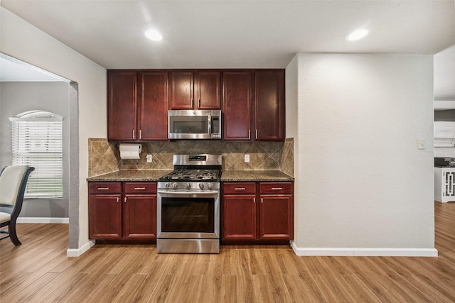16743 Fallen Timbers Dr, Conroe, TX 77385 - kitchen featuring stainless steel appliances, dark brown cabinets, light wood-style flooring, tasteful backsplash, and recessed lighting