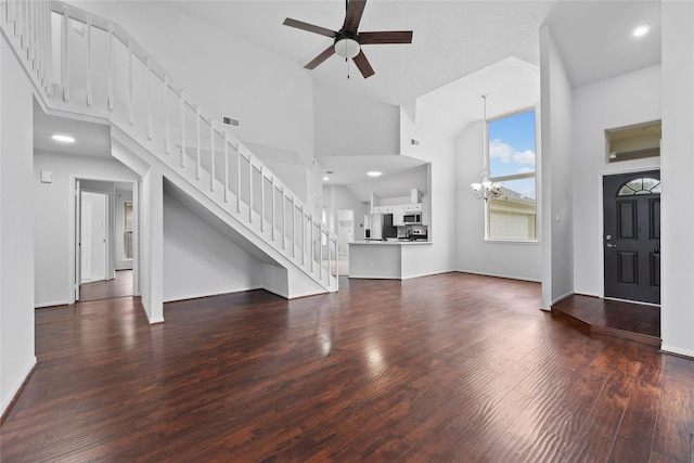 12319 Hamsfield Ct, Tomball, TX 77377 - unfurnished living room with stairway, a towering ceiling, a chandelier, wood finished floors, and a ceiling fan