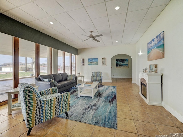 15002 Windward Dr Unit 207, Corpus Christi, TX 78418 - tiled living area featuring arched walkways, ceiling fan, a glass covered fireplace, and a paneled ceiling