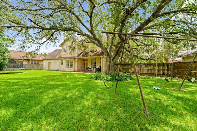 33318 Winsford St, Fulshear, TX 77441 - fenced backyard featuring a trampoline and a patio