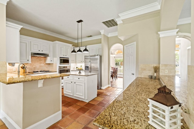 33318 Winsford St, Fulshear, TX 77441 - kitchen with appliances with stainless steel finishes, arched walkways, ornamental molding, light stone counters, and a peninsula