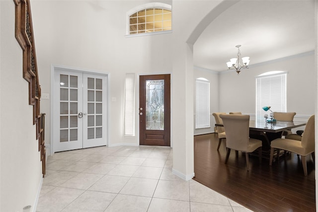 3922 Crestwind Ln, Richmond, TX 77407 - entryway featuring a chandelier, arched walkways, french doors, crown molding, and light tile patterned flooring