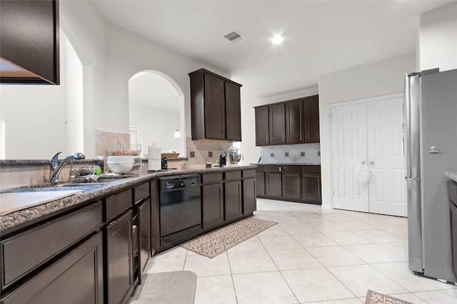3922 Crestwind Ln, Richmond, TX 77407 - kitchen featuring dishwasher, freestanding refrigerator, arched walkways, tasteful backsplash, and dark brown cabinetry