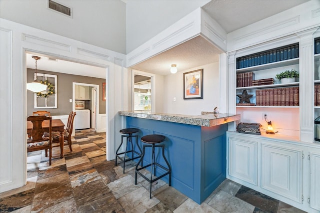 14615 Sunny Grove Dr, Houston, TX 77070 - bar with dark stone finish floors and decorative light fixtures