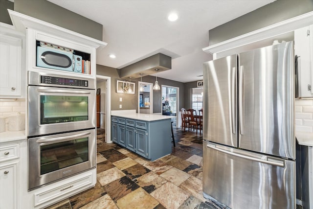 14615 Sunny Grove Dr, Houston, TX 77070 - kitchen with appliances with stainless steel finishes, backsplash, light countertops, blue cabinets, and recessed lighting