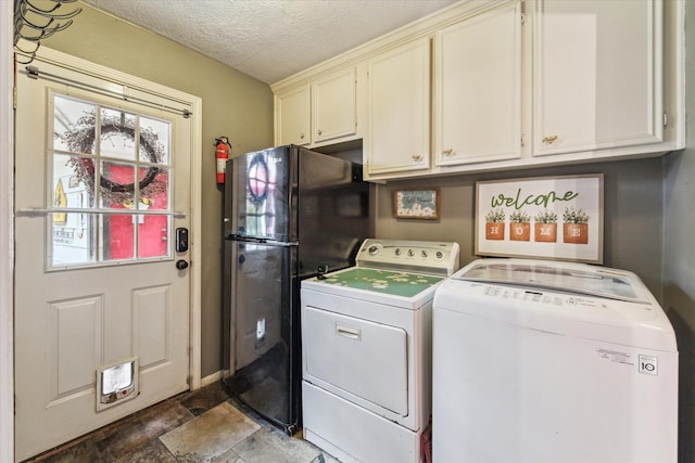14615 Sunny Grove Dr, Houston, TX 77070 - washroom featuring cabinet space, washing machine and clothes dryer, a textured ceiling, and stone finish floors