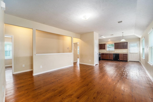 12006 Gregory Crossing Way, Houston, TX 77067 - unfurnished living room featuring dark wood finished floors, vaulted ceiling, and a textured ceiling