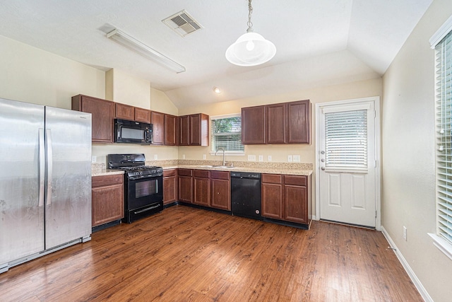 12006 Gregory Crossing Way, Houston, TX 77067 - kitchen with black appliances, vaulted ceiling, dark wood-style flooring, and hanging light fixtures