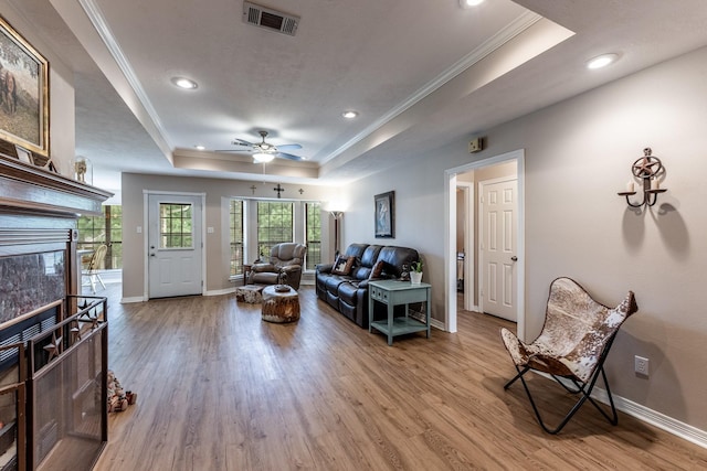 1608 Durham Dr, Huntsville, TX 77340 - living room featuring a raised ceiling, crown molding, recessed lighting, light wood-style flooring, and a ceiling fan