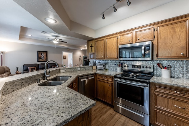 1608 Durham Dr, Huntsville, TX 77340 - kitchen with appliances with stainless steel finishes, open floor plan, light stone counters, brown cabinets, and recessed lighting