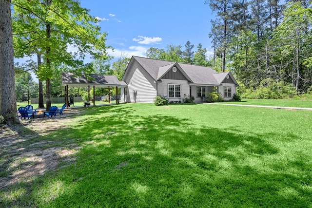 683 Cross Timbers, Livingston, TX 77351 - view of front of property featuring an outdoor fire pit, board and batten siding, and a front lawn