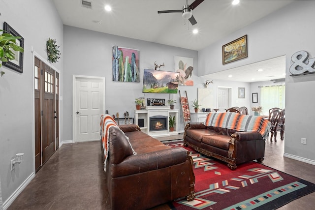683 Cross Timbers, Livingston, TX 77351 - living area featuring concrete floors, ceiling fan, recessed lighting, a lit fireplace, and a towering ceiling