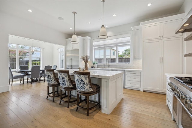 6626 Westchester Ave, West University Place, TX 77005 - kitchen with appliances with stainless steel finishes, plenty of natural light, a kitchen island, white cabinets, and recessed lighting