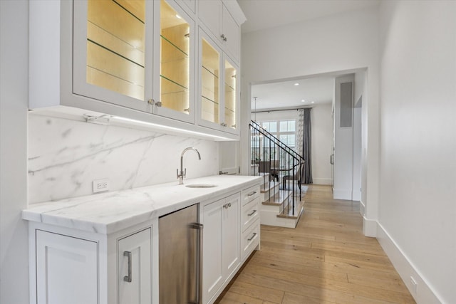6626 Westchester Ave, West University Place, TX 77005 - indoor wet bar with light wood finished floors, fridge, tasteful backsplash, stairway, and recessed lighting