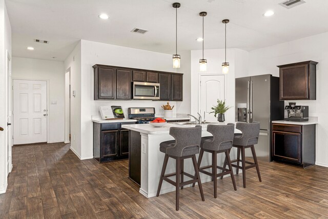 5122 Moonlit Garden Ln, Katy, TX 77449 - kitchen featuring appliances with stainless steel finishes, dark wood-style flooring, light countertops, dark brown cabinets, and recessed lighting