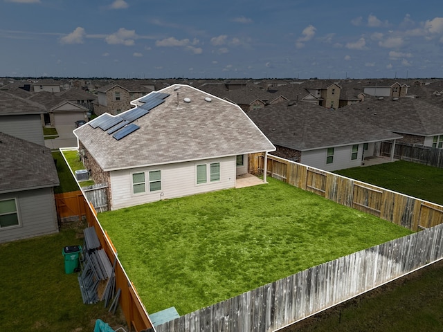 5122 Moonlit Garden Ln, Katy, TX 77449 - rear view of house with a residential view, solar panels, a fenced backyard, and roof with shingles