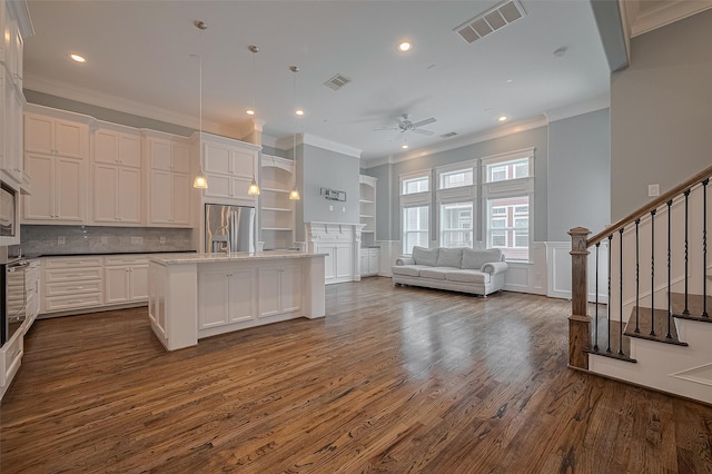2106 Bidwell Dr, Houston, TX 77018 - kitchen featuring appliances with stainless steel finishes, ornamental molding, dark wood-type flooring, ceiling fan, and white cabinetry