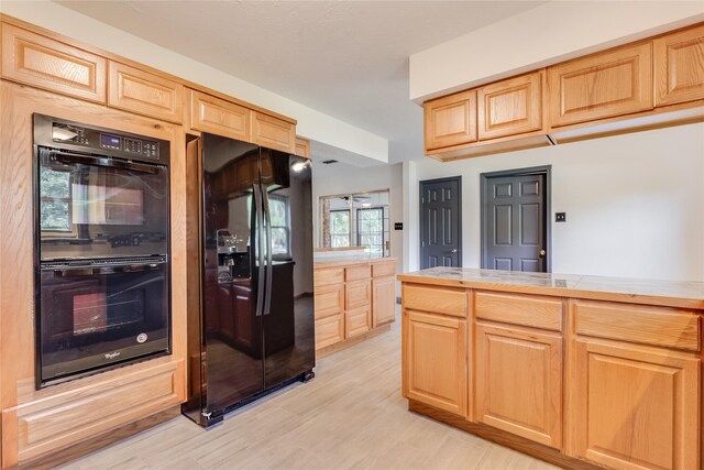 2004 Sleepy Hollow Dr, Pearland, TX 77581 - kitchen with black appliances, light brown cabinets, and light wood-type flooring