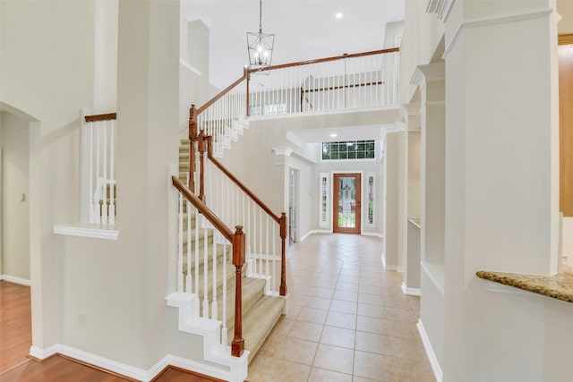 17422 Sunset Arbor Dr, Tomball, TX 77377 - foyer entrance featuring a high ceiling, a chandelier, stairs, light tile patterned floors, and arched walkways