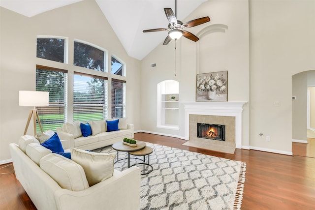 17422 Sunset Arbor Dr, Tomball, TX 77377 - living room featuring wood finished floors, ceiling fan, high vaulted ceiling, arched walkways, and a fireplace