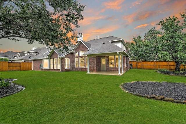 17422 Sunset Arbor Dr, Tomball, TX 77377 - back of house at dusk featuring brick siding, a patio area, a fenced backyard, and a chimney