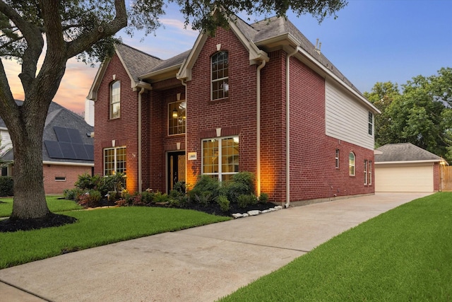 1611 Barrington Hills Ln, Katy, TX 77450 - traditional home with brick siding, an outdoor structure, a front lawn, roof with shingles, and a detached garage