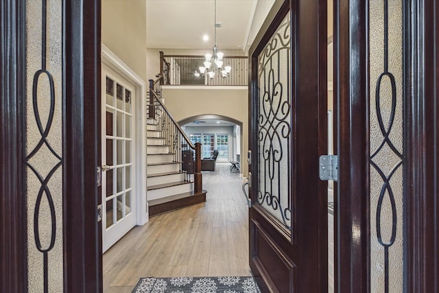 1611 Barrington Hills Ln, Katy, TX 77450 - entryway featuring arched walkways, wood finished floors, stairway, a chandelier, and french doors