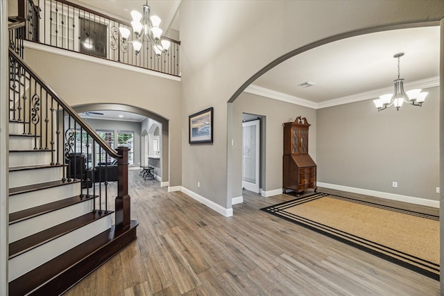 1611 Barrington Hills Ln, Katy, TX 77450 - entrance foyer featuring a chandelier, arched walkways, wood finished floors, ornamental molding, and stairs