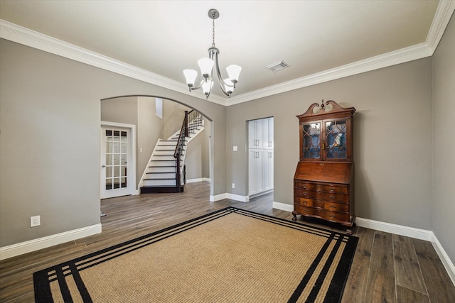 1611 Barrington Hills Ln, Katy, TX 77450 - unfurnished room with arched walkways, a chandelier, wood finished floors, ornamental molding, and stairway