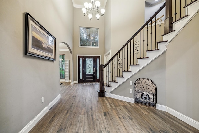 1611 Barrington Hills Ln, Katy, TX 77450 - foyer entrance with wood finished floors, a chandelier, a high ceiling, arched walkways, and stairway