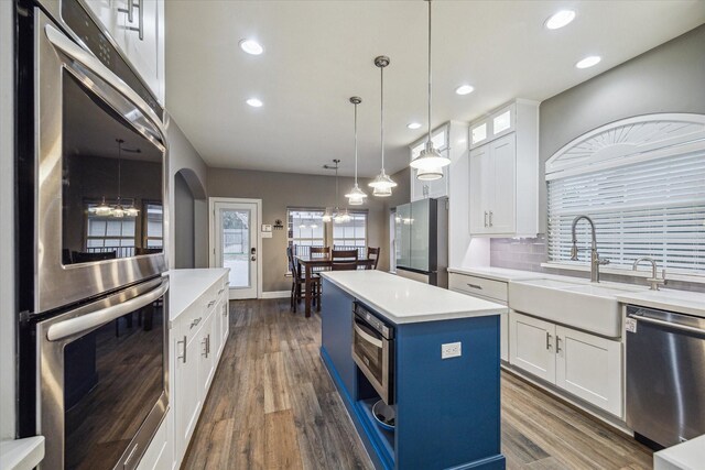 1611 Barrington Hills Ln, Katy, TX 77450 - kitchen featuring stainless steel appliances, dark wood-style flooring, white cabinets, a center island, and recessed lighting