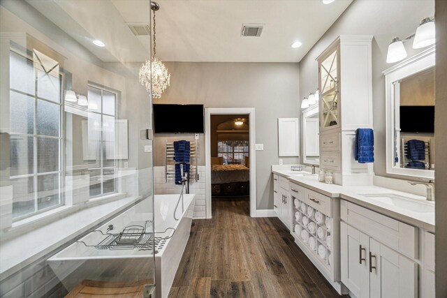 1611 Barrington Hills Ln, Katy, TX 77450 - ensuite bathroom with a tub to relax in, double vanity, wood finished floors, a chandelier, and recessed lighting