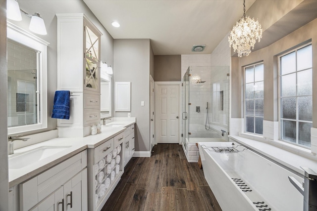 1611 Barrington Hills Ln, Katy, TX 77450 - full bathroom featuring a shower stall, a soaking tub, double vanity, a chandelier, and wood finished floors