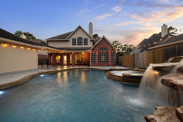 1611 Barrington Hills Ln, Katy, TX 77450 - pool at dusk with a pool with connected hot tub and a patio area