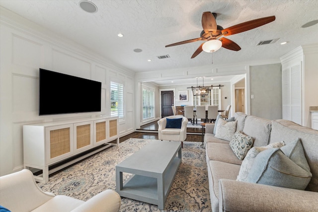 2603 Haverhill Dr, Houston, TX 77008 - living room featuring ceiling fan, crown molding, a textured ceiling, wood finished floors, and a chandelier
