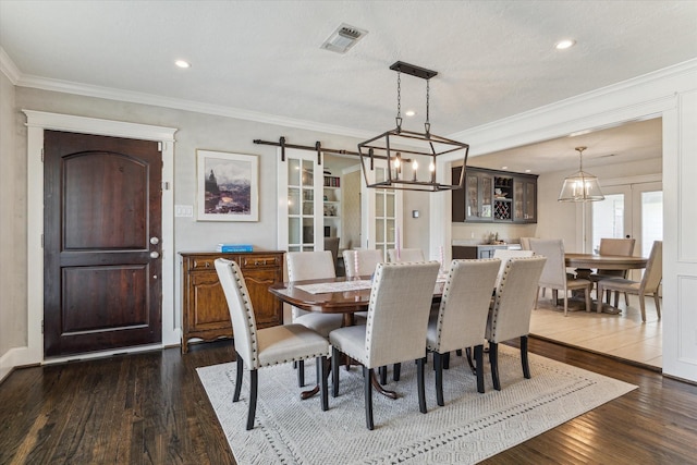 2603 Haverhill Dr, Houston, TX 77008 - dining area featuring a barn door, dark wood-style flooring, crown molding, and recessed lighting