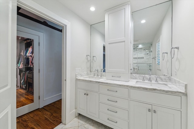 2603 Haverhill Dr, Houston, TX 77008 - full bath with a stall shower, double vanity, recessed lighting, a walk in closet, and wood finished floors