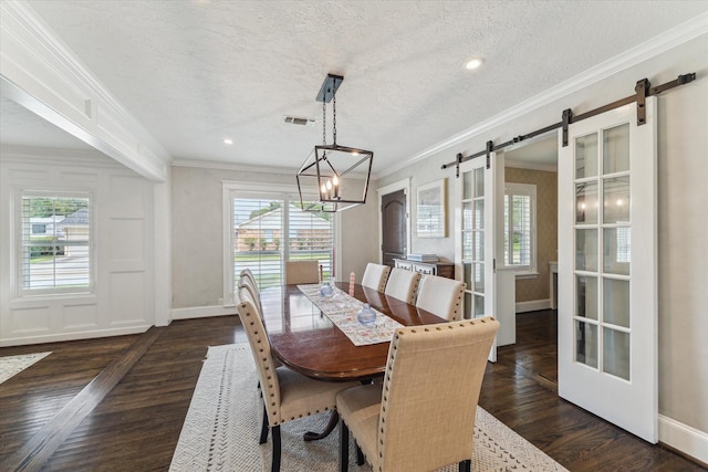 2603 Haverhill Dr, Houston, TX 77008 - dining space featuring a barn door, healthy amount of natural light, ornamental molding, dark wood-type flooring, and a chandelier