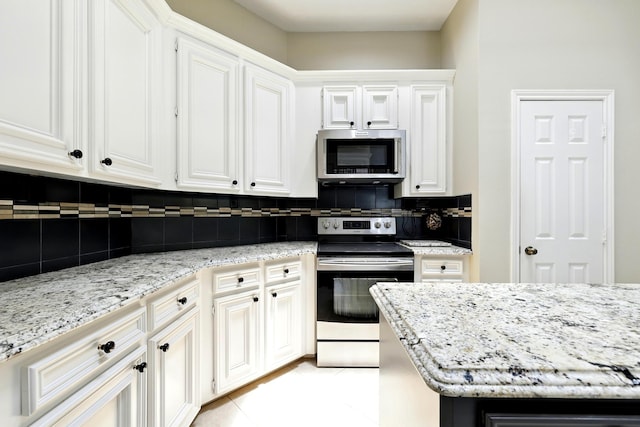 24806 Silver Leaf St, Magnolia, TX 77355 - kitchen with appliances with stainless steel finishes, decorative backsplash, light stone countertops, and white cabinetry