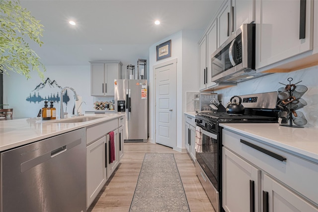 7822 Murciana Dr, Rosharon, TX 77583 - kitchen featuring appliances with stainless steel finishes, light countertops, backsplash, light wood-style flooring, and recessed lighting